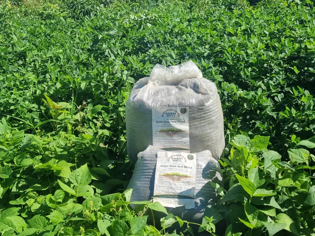 Happy Roots 25 kilogram bags displayed among green crops